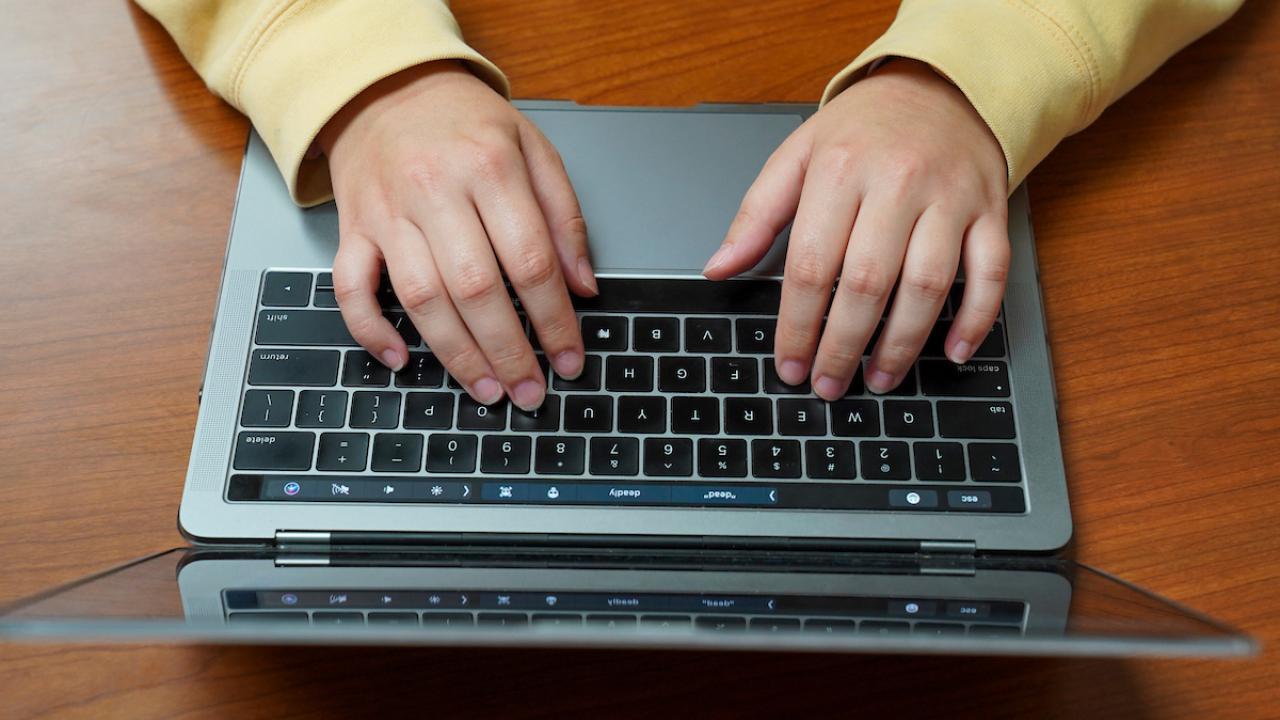 Photo of person typing on laptop